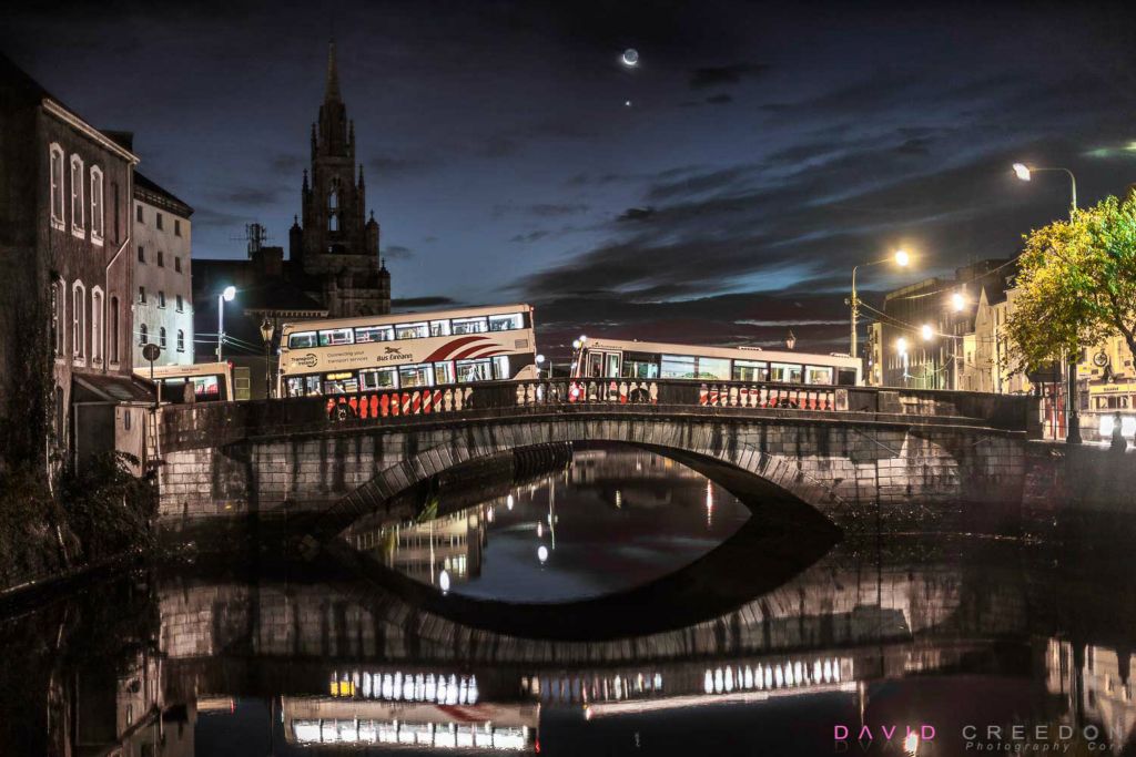 Early morning buses cross Parliament Bridge to begin their daily service around the city