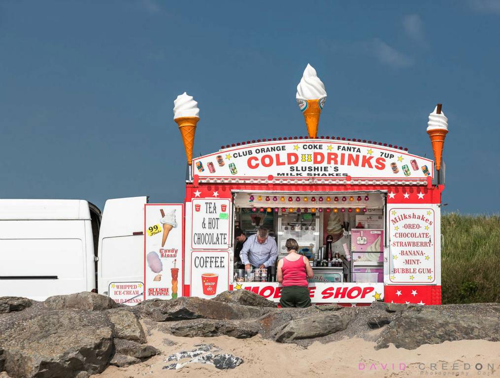 As the summer temperature begins to rise, Una Murphy from Dunderrow buys an ice cream from Frank Williams in his mobile shop on the beach front in Garrettstown, Co. Cork, Ireland.