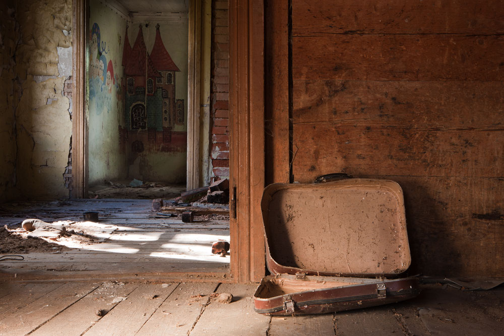 The harrowing partition of families can be witnessed in empty homes that are scattered throughout the countryside, some stripped bare. Here an old broken suitcase is all that's left in a hallway of an abandoned house near Skrunda.