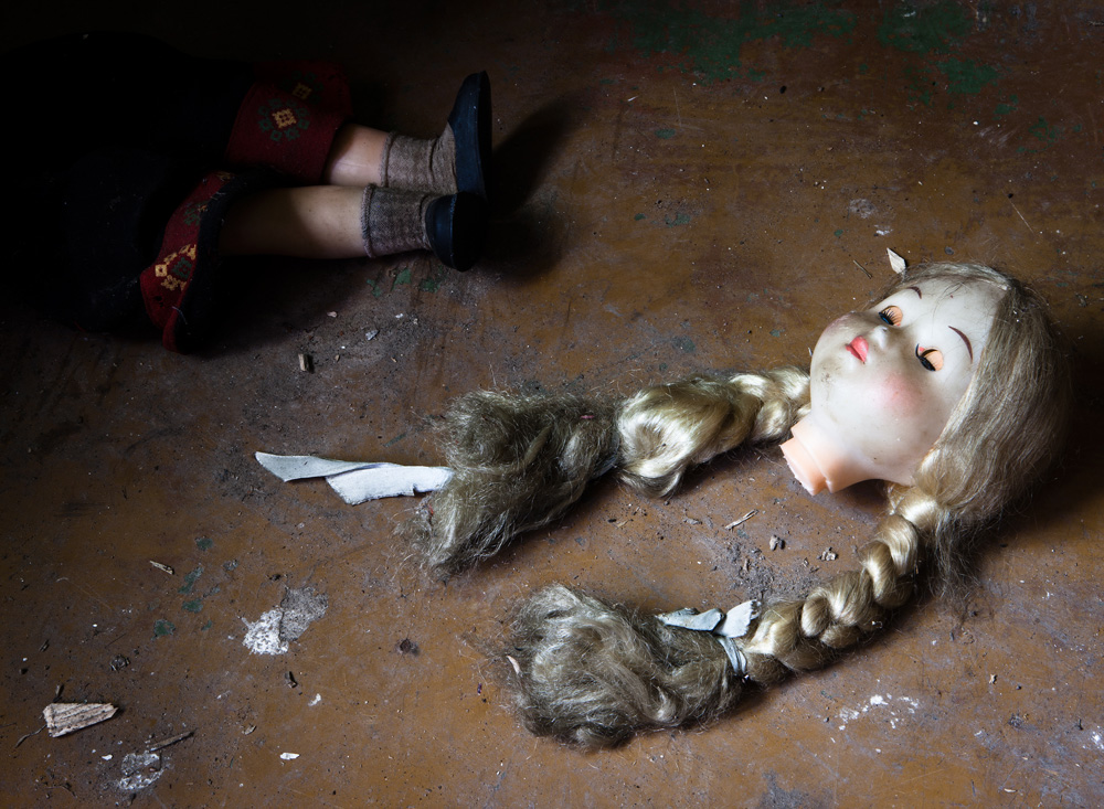 A doll now broken lies on the floor of  an abandonded home near Kuldiga
