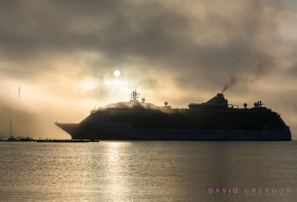 Coastal fog and a rising sun greet cruise liner Jewel of the Seas as it approachs her berth in Cobh, Co. Cork, Ireland. 