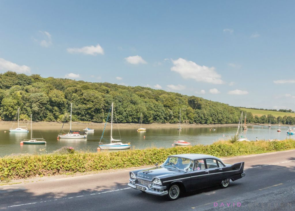 Bill and Kate Ryan take their 1957 Dodge Kingsway for a sunday spin on a gorgeous summer's day passing moored yachs at Drake's Pool outside Crosshaven, Co. Cork, Ireland.