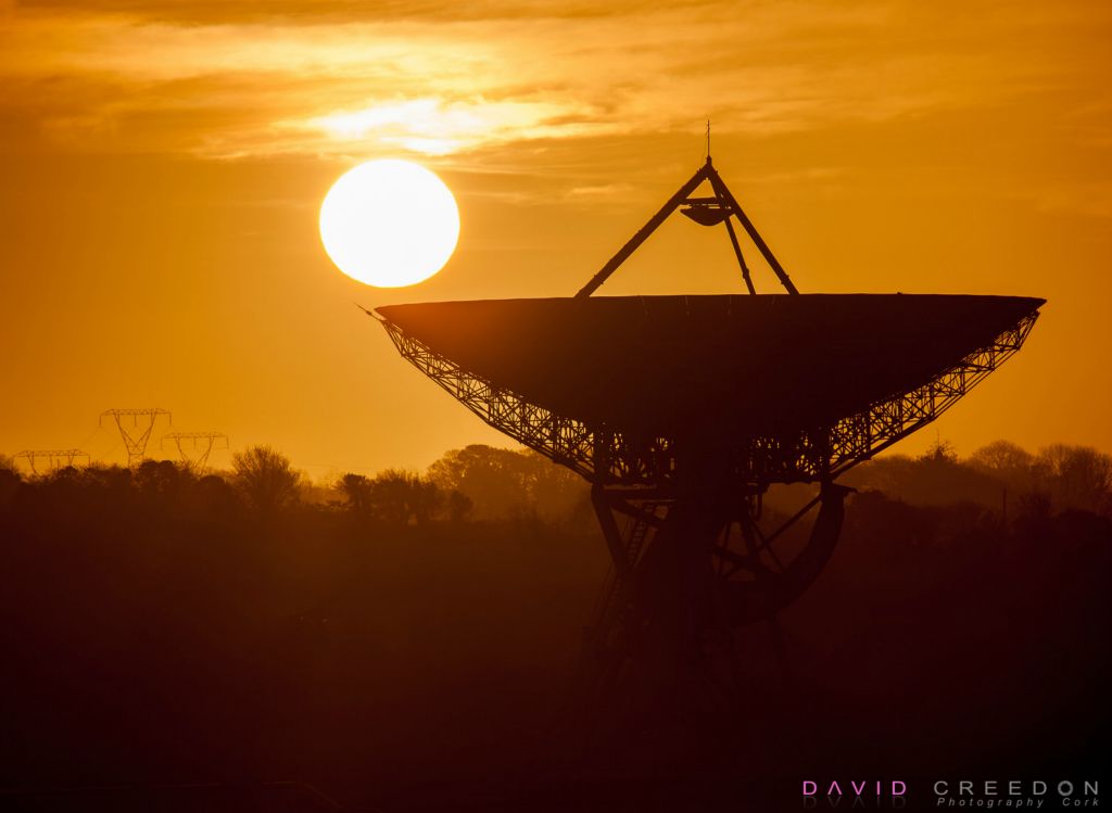 The Sun begings to rise behind the giant communications Dish at the National Space Centre Earthstation at  Elfordstown, outside Midleton, Co. Cork, Ireland.