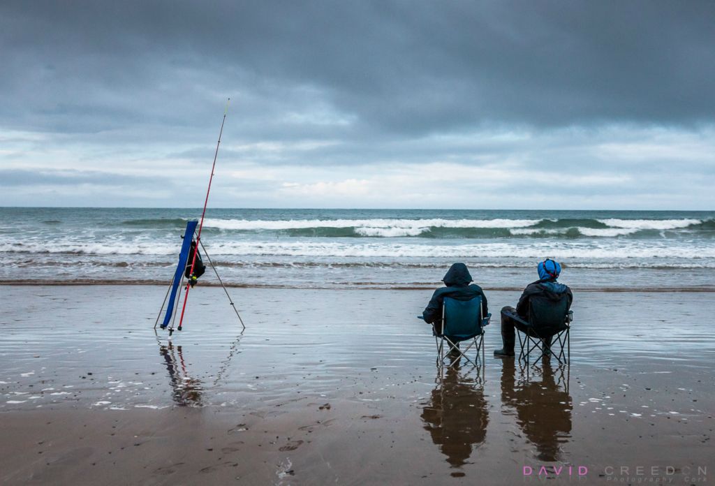 Dawn fishermen Lina Ruikyte from Kinsale and Gintautas Dubaka, Cork City sit and wait for the first bite of the day while fishing for sea Bass at Garrylucas, Co. Cork, Ireland. 