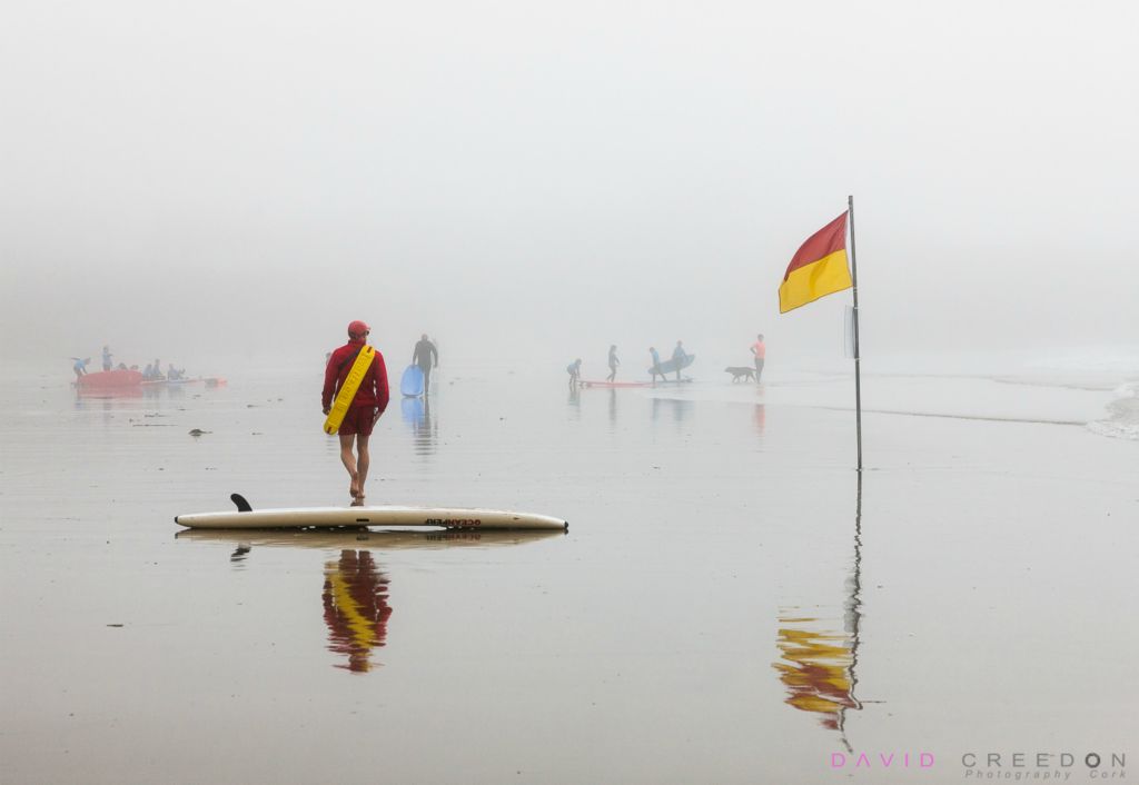 A lifeguard patrols the beach on a misty morning while keeping an eye on sufers and swimmers at Garrettstown, Co. Cork, Ireland. 