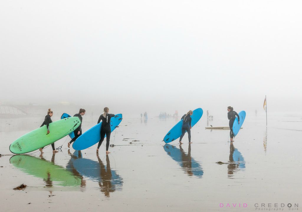 Five girls walk to the sea for a morning of surfing at Garrettstown, Co. Cork, Ireland.
